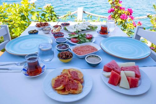 a white table with plates of food on it at Aphrodite Hotel Bozburun in Bozburun