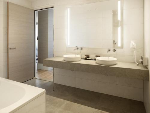 a bathroom with two sinks and a mirror at Van der Valk Hotel Den Haag in Nootdorp