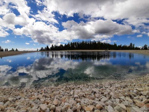 a large body of water with rocks in the water at JUFA Hotel Hochrindl in Hochrindl