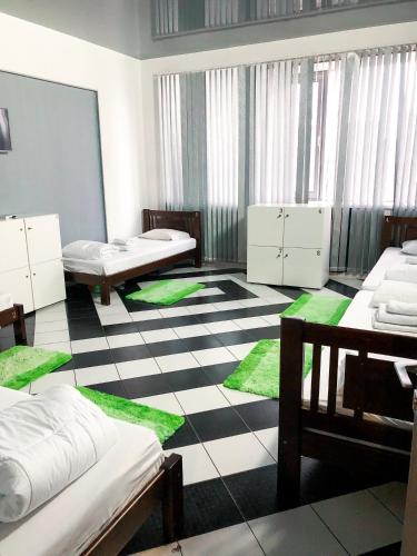 um quarto com duas camas e tapetes verdes no chão em Hotel Zipper House em Odessa