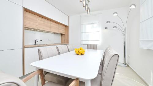 a white dining room with a white table and chairs at Villa Leon in Brtonigla