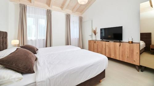 a bedroom with a large bed and a flat screen tv at Villa Leon in Brtonigla