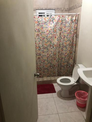a bathroom with a toilet and a shower curtain at ApartmentsWestvillage 2bedroom in Montego Bay