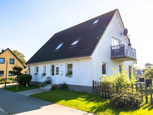 a white house with a black roof at Ferienwohnung Sukow in Freest