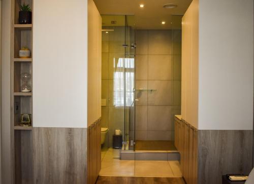 a bathroom with a shower with a glass door at Red Velvet - Lux One Bedroom in Pretoria