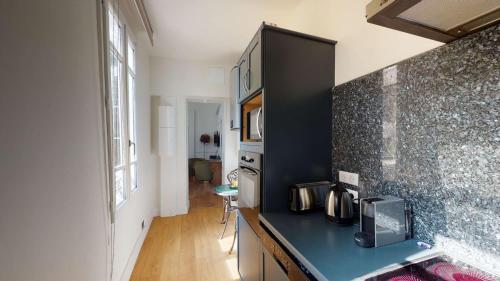 une cuisine avec un comptoir noir dans une pièce dans l'établissement La Suite Royale, à Rouen