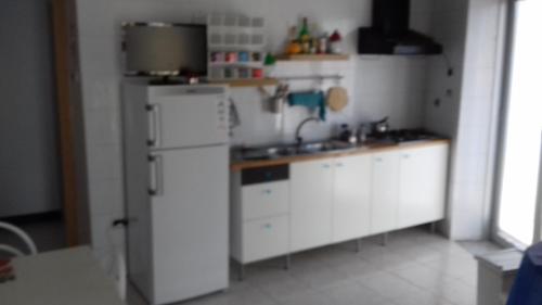 eine Küche mit weißen Schränken und einem weißen Kühlschrank in der Unterkunft beb Business Mini Appartamento in Casalnuovo di Napoli