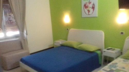 ein kleines Schlafzimmer mit einem Bett und einer grünen Wand in der Unterkunft beb Business Mini Appartamento in Casalnuovo di Napoli