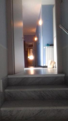 einen Flur mit einer Treppe, die zu einem Zimmer mit einem Spiegel führt in der Unterkunft beb Business Mini Appartamento in Casalnuovo di Napoli