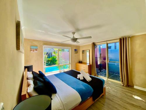 a bedroom with a large bed and a large window at Surf Club House, Pet Friendly, Sunshine Coast, Holiday House, Marcoola in Marcoola