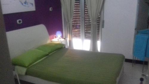 ein Schlafzimmer mit einem grünen Bett und einem Fenster in der Unterkunft beb Business Mini Appartamento in Casalnuovo di Napoli