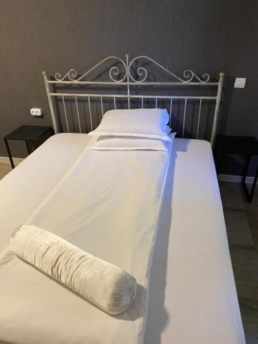 a white bed with a pillow on it at Family Hotel Amor in Ruse