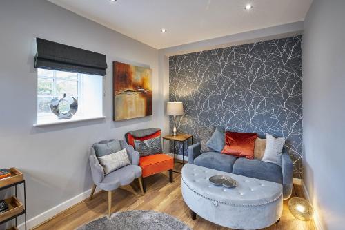 a living room with a blue couch and two chairs at Host & Stay - 82 Galgate in Barnard Castle