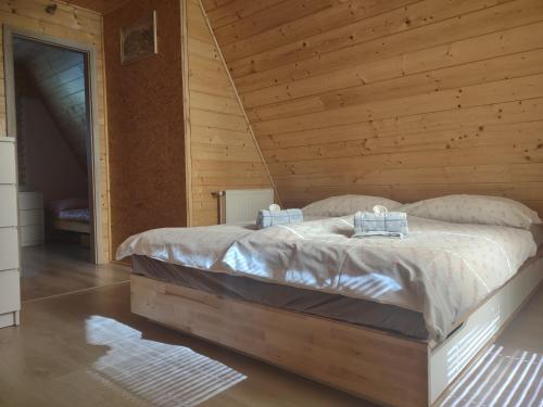 1 dormitorio con 1 cama en una cabaña de madera en Naše chatka pod Strání, en Rožnov pod Radhoštěm