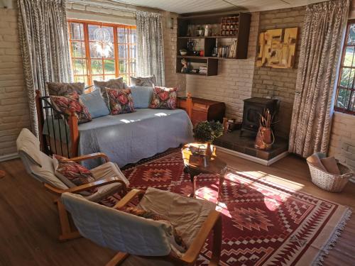 a living room with a bed and a couch at Athanor Cottages in Hogsback