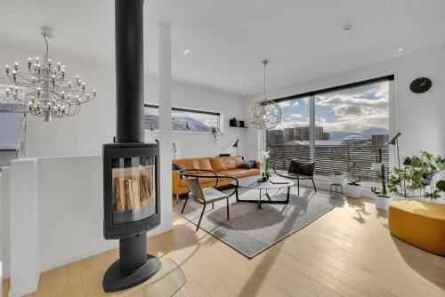 salon z kominkiem i kanapą w obiekcie Kais sauna, jacuzzi, cinema and balcony house! Central location w mieście Tromsø
