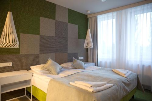 a bedroom with a bed with towels on it at Hotel Quattro in Szczecinek