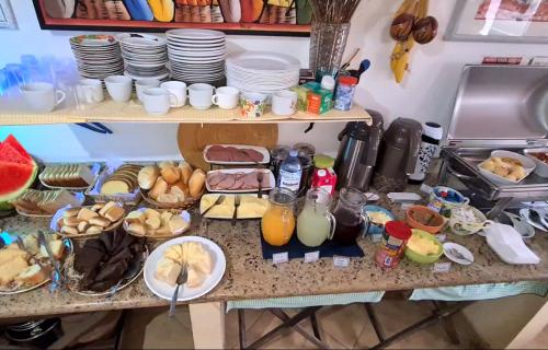 a table with food and plates and drinks on it at Hotel Iracemar - Econômico in Guarujá