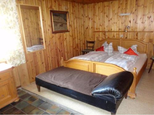 ein Schlafzimmer mit einem Bett mit einem schwarzen Ledersitz in der Unterkunft Hendlmühle in Wondreb