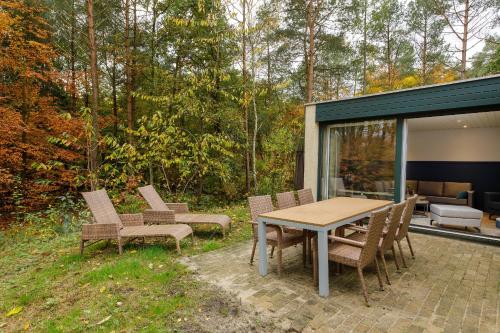 a patio with a wooden table and chairs at Center Parcs Bispinger Lüneburger Heide in Bispingen