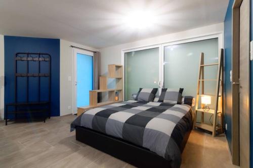 a bedroom with a black and white bed and blue walls at La birette in Vignoux-sur-Barangeon