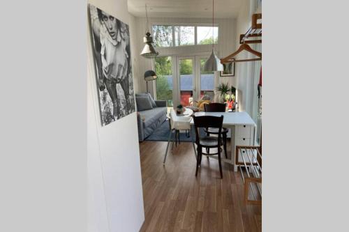 a kitchen and living room with a table and chairs at Cabin in the woods, close to Lake Mälaren in Eskilstuna