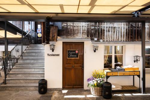 a building with a wooden door and a stairs at Swiss-Chalet Merlischachen - Historik Chalet-Hotel Lodge in Küssnacht