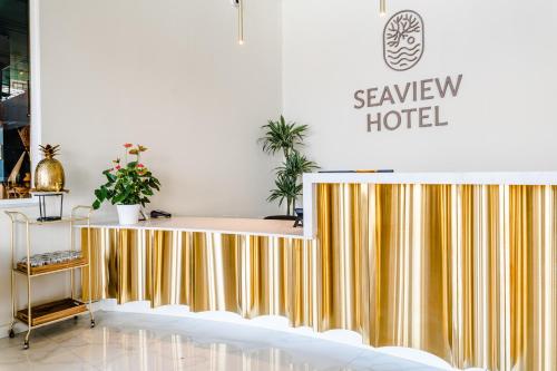 a hotel lobby with a gold and white reception desk at Seaview Hotel - Adults Only 16 Plus in St Paul's Bay