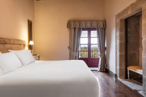 a bedroom with a large bed and a window at Áurea Palacio de Sober by Eurostars Hotel Company in Sober