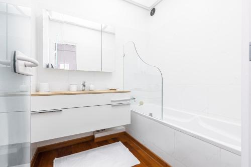 La salle de bains blanche est pourvue de placards blancs et d'un miroir. dans l'établissement FEEL HOME - GRIMALDI, à Nice