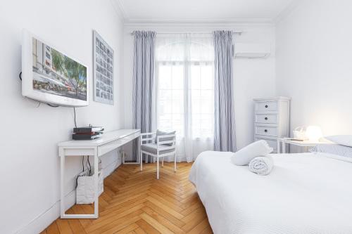 - une chambre blanche avec 2 lits et un bureau dans l'établissement FEEL HOME - GRIMALDI, à Nice