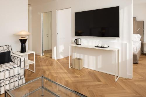 a living room with a tv on a white wall at Hotel Morfeo in Milan
