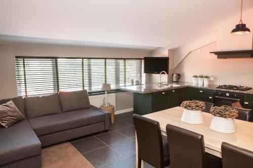 een keuken en een woonkamer met een bank en een tafel bij Hotel-Herberg D'n Dries in Drunen