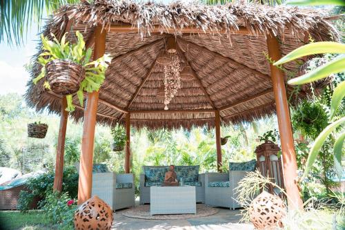 a large straw pavilion with a woman sitting in it at Pousada Villa del Lótus in Itarema