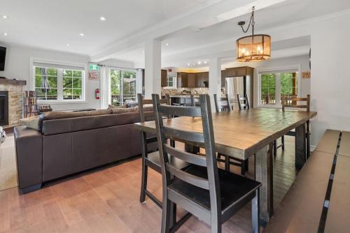 a dining room and living room with a table and a couch at Scandia Retreat with Hot Tub, Sauna and Fire Pit in Blue Mountains