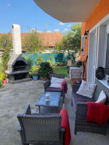 eine Terrasse mit Stühlen, Tischen und einem Kamin in der Unterkunft Ubytovanie Dana in Piešťany