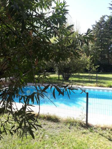 a fence around a swimming pool in a park at La casita en el parque in Chacras de Coria
