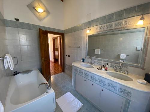 bagno con 2 lavandini, vasca e specchio di Appartamenti Apollo XI, GTSGroup a Tignale