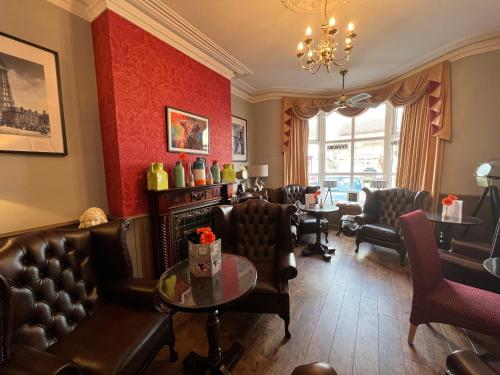 una sala de espera en una barbería con muebles de cuero en Raffles Hotel, en Blackpool