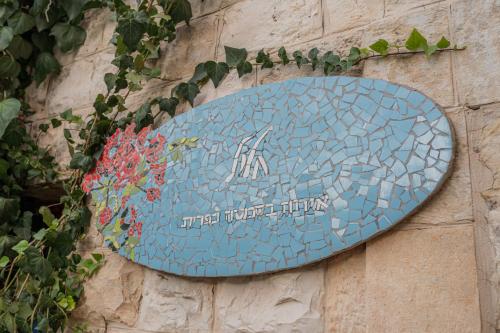 a blue tile sign on the side of a wall at Khalil lane in the Village in Mi‘ilyā