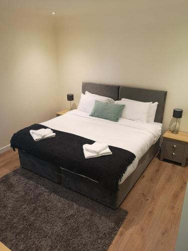 a bedroom with a large bed with two towels on it at Arrochoile Cottage in Glasgow