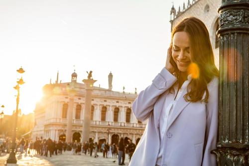 a woman standing in front of a building at Baglioni Hotel Luna - The Leading Hotels of the World in Venice