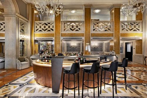 a bar in a hotel lobby with black stools at Baglioni Hotel Luna - The Leading Hotels of the World in Venice