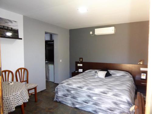 a bedroom with a bed and a table and chairs at El Rincón de los Patos 1 in Serranillos Playa