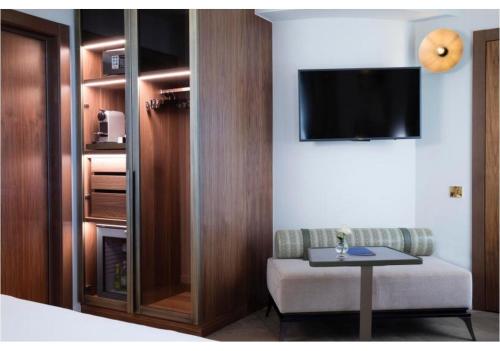 a hotel room with a bed and a tv on a wall at Maison Bréguet in Paris