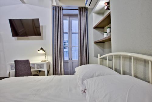 1 dormitorio con 1 cama, escritorio y TV en Chateau La Vallette - St. Elmo Suite, en La Valeta