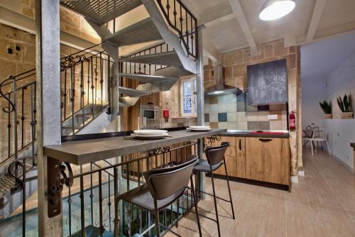 una cocina con barra con taburetes en Chateau La Vallette - St. Elmo Suite, en La Valeta