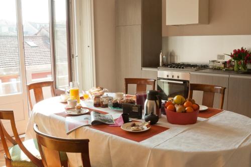 a kitchen table with a white table cloth and fruit on it at Casatitta Bed & Breakfast in Milan