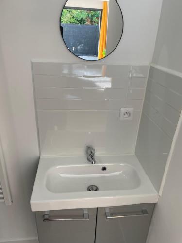 une salle de bain avec un lavabo et un miroir dans l'établissement studio 2 RDC henriville, à Amiens