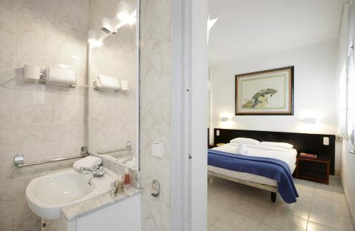 a bathroom with a sink and a bed in a room at Apartamentos Calvet in Barcelona